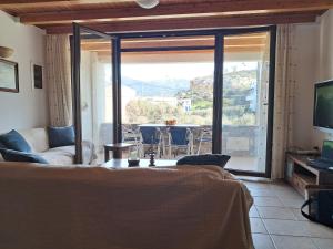 een woonkamer met een bank en een televisie bij Koxylia apts in Mochlos