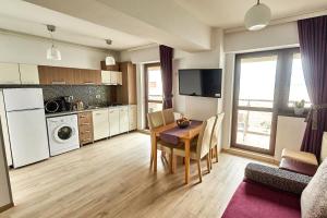 a living room with a table and a kitchen at Miraj Apartaments - Exclusive Residence in Mamaia