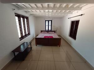 a bedroom with a bed in the middle of a room at Wintervilla Cottages in Meppādi