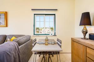 ein Wohnzimmer mit Sofa und Tisch in der Unterkunft Colina Verde G - Charming 1-Bedroom Townhouse in Carvoeiro