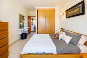 ein Schlafzimmer mit einem Bett, auf dem ein Teddybär liegt in der Unterkunft Colina Verde G - Charming 1-Bedroom Townhouse in Carvoeiro