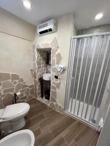 a bathroom with a stone shower and a toilet at Family in Massafra