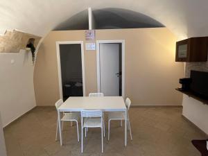 a dining room with a white table and chairs at Family in Massafra