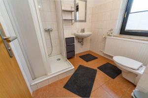 a bathroom with a shower and a toilet and a sink at Ferienwohnung Haus am Seeufer Steuerbord in Waren +16 photos