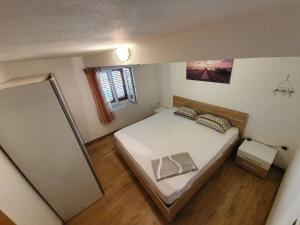 a small bedroom with a bed and a mirror at Apartman u centru Komiže in Komiža
