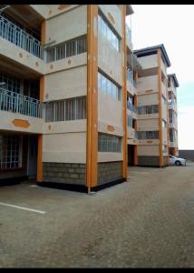 a large apartment building with a car parked next to it at D & C Homes in Eldoret