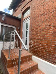 a brick building with a staircase next to a door at Haus Schönborn Norden Family in Norden