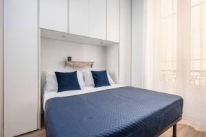 a bedroom with a bed with blue sheets and a window at Classbnb - 2 comfortable apartments in Monte Carlo in Beausoleil