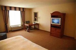 a hotel room with a bed and a television and a desk at Hilton Garden Inn Grand Forks/UND in Grand Forks