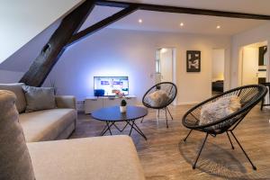 un salon avec un canapé, des chaises et une table dans l'établissement Fewomo, Historisches Moselflair Apartment, 6 Personen, Stilvoll & Komfortabel für deinen Urlaub, à Lieser