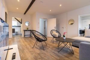 un salon avec deux chaises et une table dans l'établissement Fewomo, Historisches Moselflair Apartment, 6 Personen, Stilvoll & Komfortabel für deinen Urlaub, à Lieser