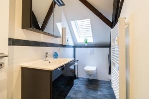 une salle de bain avec un lavabo et des toilettes dans l'établissement Fewomo, Historisches Moselflair Apartment, 6 Personen, Stilvoll & Komfortabel für deinen Urlaub, à Lieser