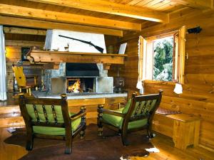 two chairs in a living room with a fireplace at Chalet Tradizionale con bel giardino in Champoluc