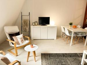 Una sala de estar con televisión, mesa y sillas. en Baladrias 501, en Formigal