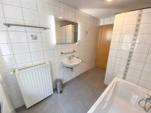 a bathroom with a sink and a tub and a mirror at Welcoming house in Stavelot with sauna and garden in Francheville +26 photos