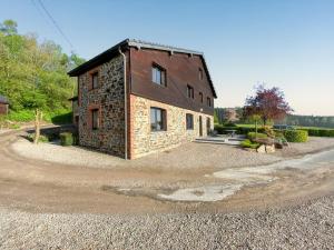 a brick house on a gravel road next to a building at Welcoming house in Stavelot with sauna and garden in Francheville