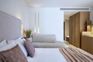 a bedroom with a large white bed with pillows at Princess Resort, Santikos Collection in Agia Paraskevi