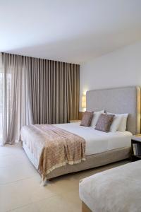 a hotel room with two beds and a window at Princess Resort, Santikos Collection in Agia Paraskevi