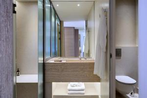 a bathroom with a sink and a toilet and a mirror at Princess Resort, Santikos Collection in Agia Paraskevi