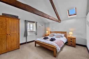 a bedroom with a large bed and a wooden cabinet at Finest Retreats - Cowslip in Bradworthy
