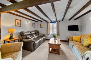 a living room with a couch and a tv at Finest Retreats - Cowslip in Bradworthy