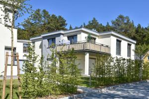 una casa bianca con un balcone di Sonnenpark 02 a Korswandt