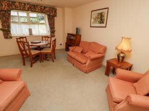 a living room with orange furniture and a table at Ivy Cottage in Wooler