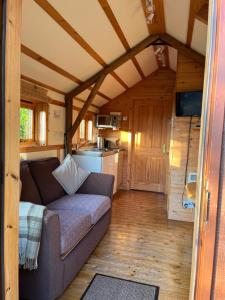 a living room with a couch in a tiny house at Bower Pods in Bowermadden