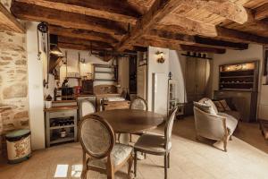a kitchen with a table and chairs in a room at Bien-être & Spa privatif - Spa de nage, sauna, lit hydromassant & relaxation Immersive in Saint-Jean-Ligoure