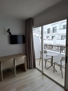 a room with a table and a view of a balcony at Sunside Ibiza Studios - Only Adults- Formerly known as Central Park in San Antonio
