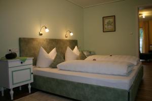 ein Schlafzimmer mit einem großen Bett mit weißen Kissen in der Unterkunft Ferienwohnungen Martinsklause in Ramsau bei Berchtesgaden