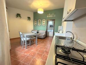 a kitchen and living room with a table and a stove at Appartamento Tramonto su Roma in Tivoli