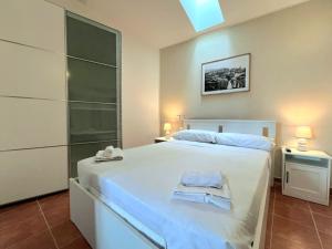 a bedroom with a white bed with towels on it at Appartamento Tramonto su Roma in Tivoli