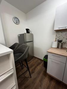 a small kitchen with a chair and a refrigerator at Apartman Crljenko in Lič +6 photos