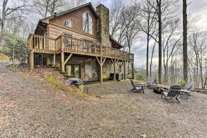 a log home with a deck and chairs in the yard at Carolina Moon Cabin in Franklin