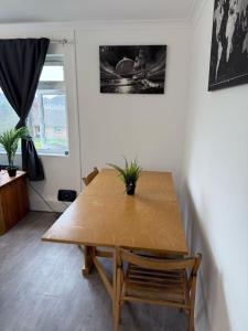 una mesa de comedor de madera en una sala de estar con ventana en Apartment !MAE11, en Kingswood