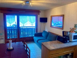 a living room with a couch and a table at Appartement Chalets du Pounant in Bellevaux