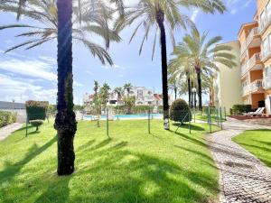 een park met palmbomen voor een gebouw bij Albufeira Modern 6 With Pool by Homing in Vale de Pedras