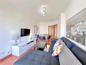 een woonkamer met een blauwe bank en een tv bij Albufeira Modern 6 With Pool by Homing in Vale de Pedras