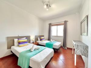 een hotelkamer met twee bedden en een raam bij Albufeira Modern 6 With Pool by Homing in Vale de Pedras +14 foto's