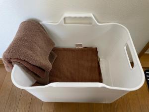 a white container with towels in it on the floor at Hakodate cozy house w/parking in Hakodate +22 photos