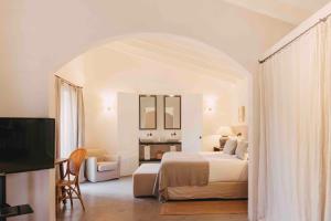 a hotel room with a bed and a tv at Finca Serena Mallorca, Small Luxury Hotels in Montuiri