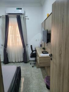 a bedroom with a bed and a desk with a computer at Nice and Cozy 1 Bed & Parlour with Starlink Wi-Fi , PlayStation, Netflix, Smart Door, 24 Hours Power, Great location in Wupa +5 photos
