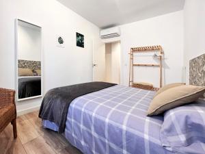 1 dormitorio con 1 cama con manta azul a cuadros en Regimiento 2, center, new, quite, parking on request, RG, en Málaga