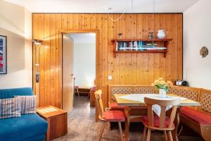 a dining room with a table and a blue couch at Haus Aretz in Feldberg