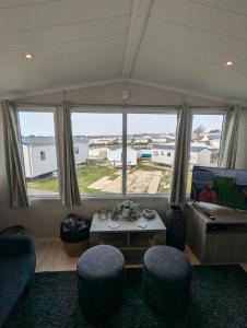 ein Wohnzimmer mit Tisch und Stühlen und einem Fernseher in der Unterkunft BEAUTIFULLY PRESENTED DOG FRIENDLY CARAVAN on VERY POPULAR LITTLESEA HOLIDAY HAVEN PARK WEYMOUTH in Weymouth + 23 Fotos
