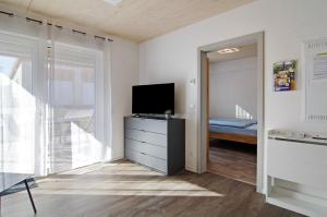 a living room with a tv and a dresser with a television at Schwäbische Alb 2 in Albstadt