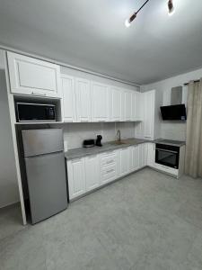a white kitchen with white cabinets and appliances at Sea Breeze Residence 2 in Mamaia Nord