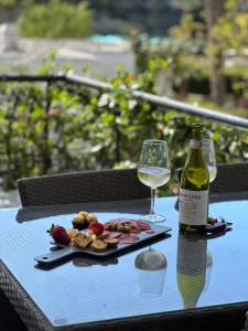 a bottle of wine and a plate of food on a table at Aquamarina Gran Canaria in Los Caideros