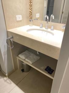 Un baño con lavabo, espejo y toallas. en Departamentos Recalada Suites, en Monte Hermoso 38 fotos más